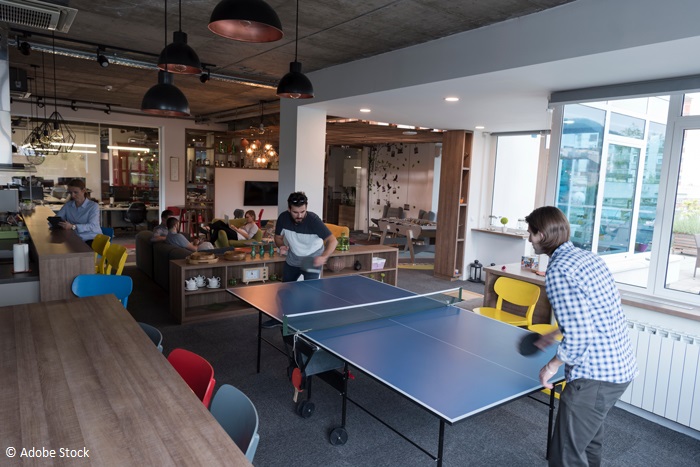 Deux salariés jouant au ping-pong dans une start-up.